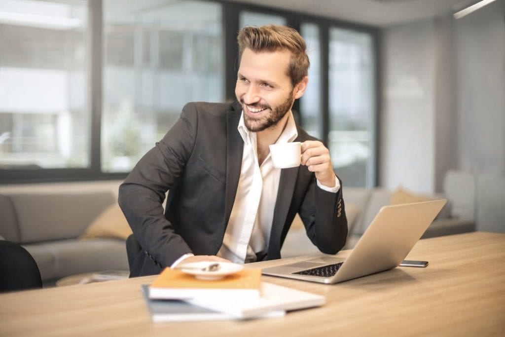 smiling business person with coffee cup and laptop